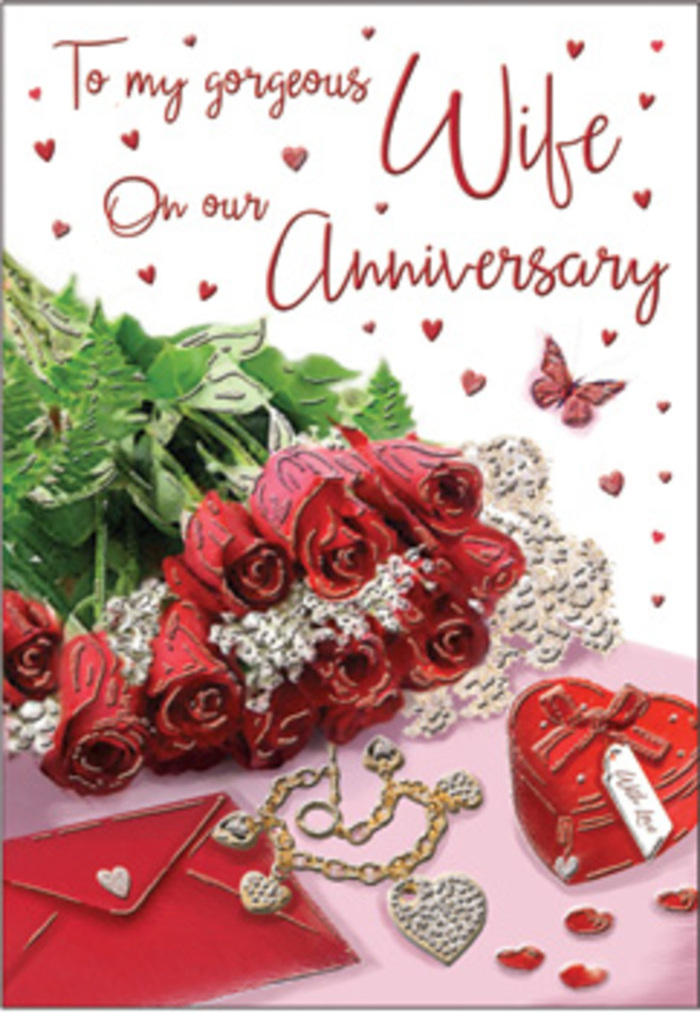 A richly layered romantic still life unfolds in this anniversary card image, as if arranged on a calm morning in a Fitzrovia apartment overlooking leafy streets near Fitzroy Square. At the centre, a bouquet of classic red roses, each bloom generously full and perfectly formed, draws the eye with its deep, saturated crimson. The petals appear almost satin-smooth, overlapping in tight, sculptural whorls that promise both fragrance and longevity, evoking roses freshly delivered from a trusted local florist. These blooms are nestled among polished green leaves and light, feathery foliage that frame the flowers without overpowering their drama, adding both texture and a sense of living abundance. The bouquet is elegantly wrapped or partially cradled against the surface of the card, with fabric-like folds and subtle shadows giving depth. Around this floral heart, a series of intimate tokens is carefully placed: a gleaming jewellery set that catches stray glints of light, a vivid red keepsake box suggesting a treasured gift, and delicate heart motifs that echo across the design. Soft lace textures and hints of velvet and silk appear in the supporting elements, creating a tapestry of touchable surfaces, from smooth metal to plush ribbon. The scripted anniversary message is styled with flowing, romantic lettering that feels handwritten, as though composed on a quiet evening near Goodge Street. Warm, diffused lighting washes over everything, smoothing edges and lending the scene a timeless, almost nostalgic glow. Together, flowers, trinkets, and typography create a tableau of shared years, whispered promises, and the quiet comfort of a love that has continued to blossom season after season.